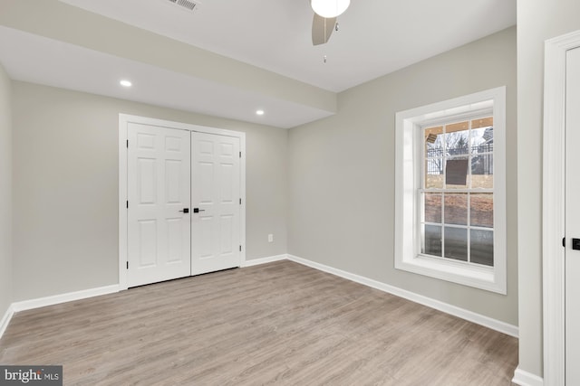 unfurnished bedroom featuring recessed lighting, a closet, baseboards, and wood finished floors