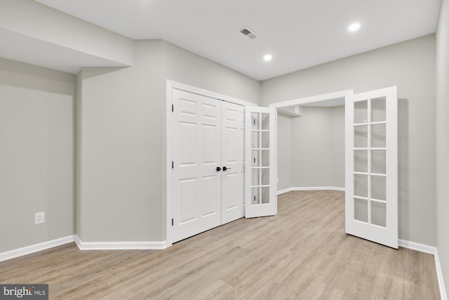 interior space featuring french doors, light wood-type flooring, visible vents, and baseboards