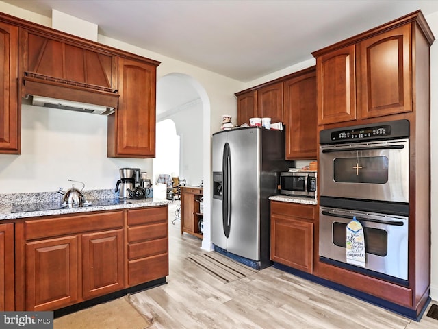 kitchen featuring light stone countertops, stainless steel appliances, and light hardwood / wood-style floors