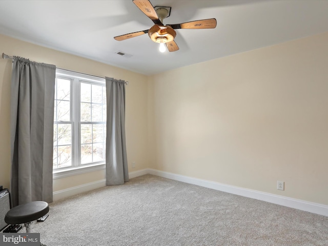 empty room featuring ceiling fan and light carpet