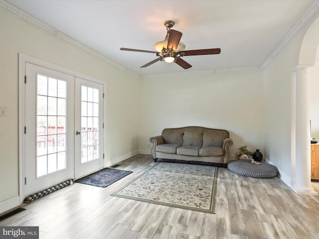 living room featuring crown molding, light hardwood / wood-style flooring, and ornate columns