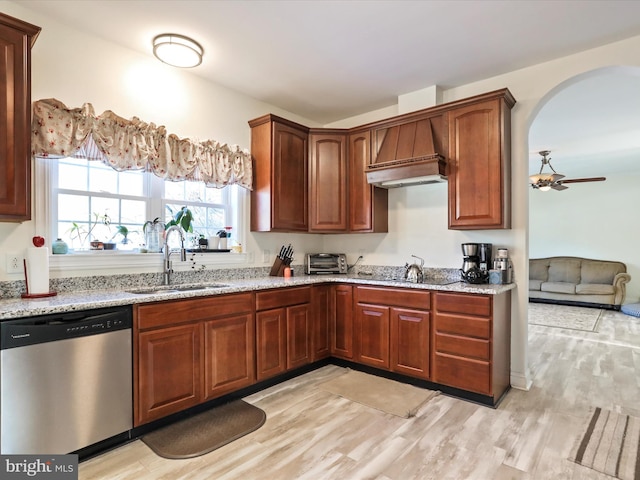 kitchen featuring stainless steel dishwasher, light stone countertops, sink, and light wood-type flooring