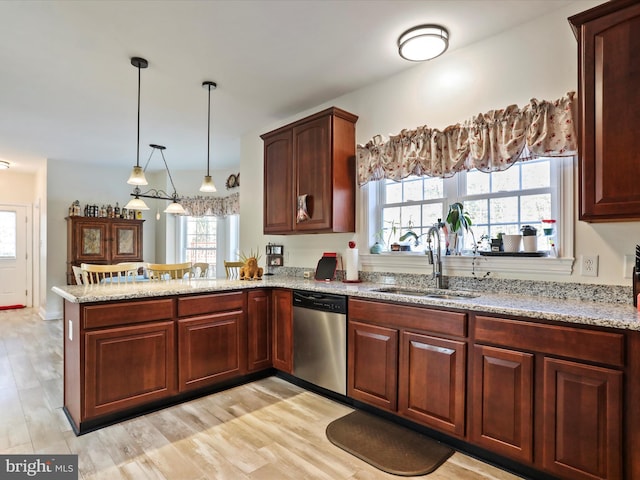 kitchen with sink, decorative light fixtures, stainless steel dishwasher, kitchen peninsula, and light stone countertops