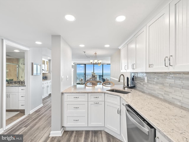 kitchen with white cabinetry, sink, stainless steel dishwasher, light stone countertops, and dark wood-type flooring