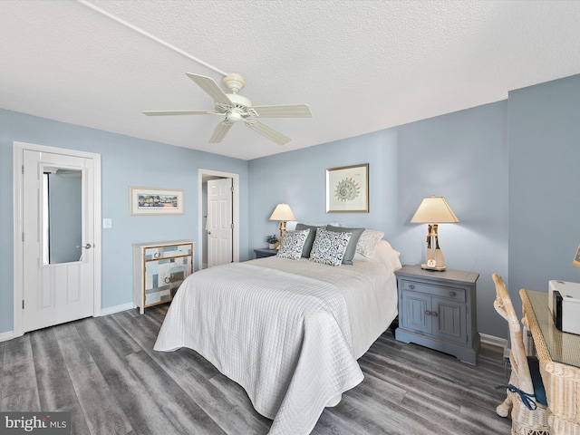 bedroom featuring dark wood-type flooring, ceiling fan, and a textured ceiling