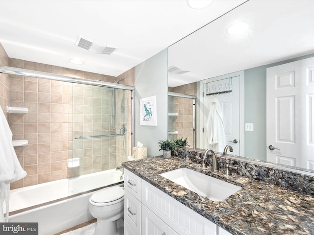 full bathroom featuring vanity, toilet, and combined bath / shower with glass door