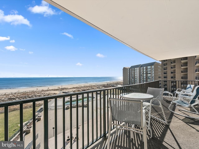 balcony with a water view and a view of the beach