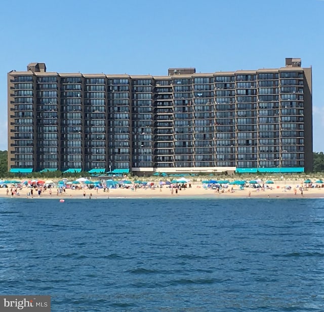 view of building exterior featuring a beach view and a water view