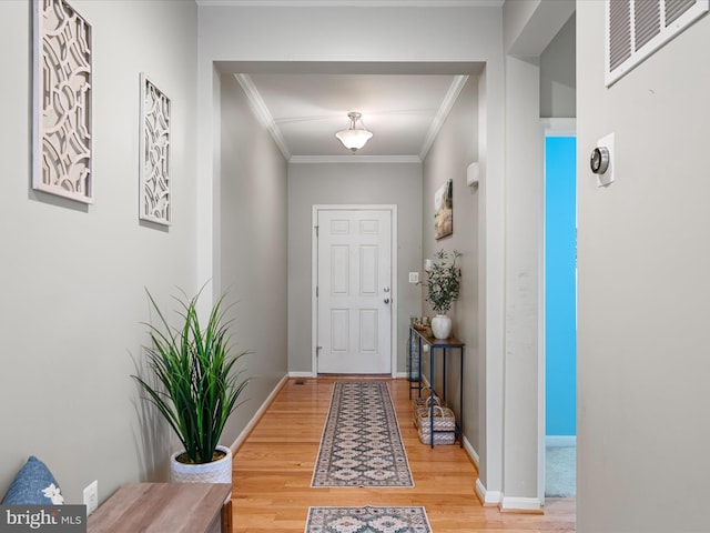 entryway featuring hardwood / wood-style flooring and ornamental molding