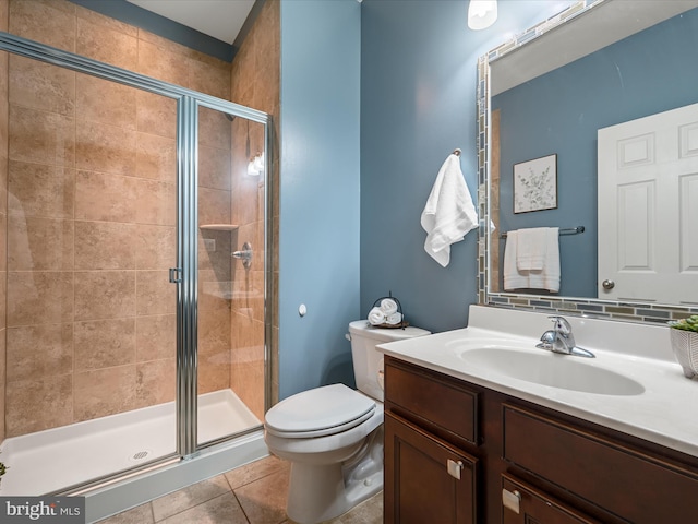 bathroom with toilet, vanity, tile patterned floors, and walk in shower