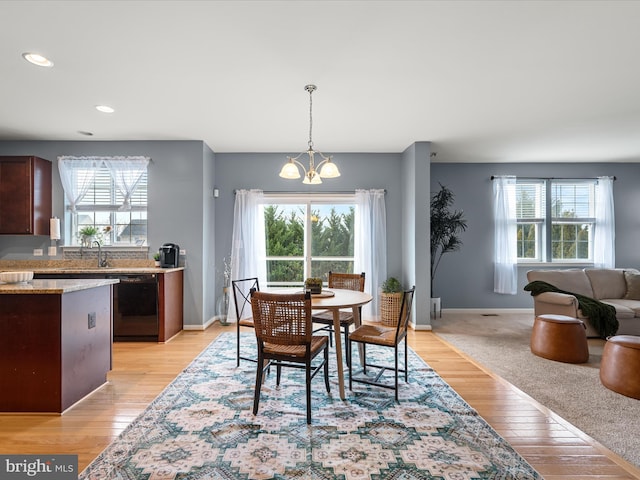 dining room featuring light wood-type flooring and a notable chandelier