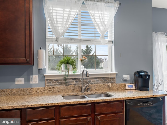 kitchen with light stone countertops, black dishwasher, sink, and backsplash