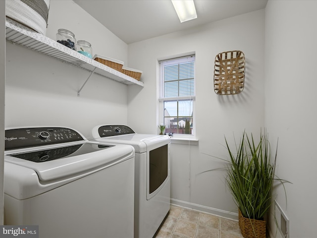 clothes washing area featuring light tile patterned floors and washer and clothes dryer