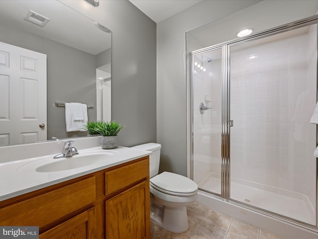 bathroom with tile patterned flooring, vanity, a shower with door, and toilet