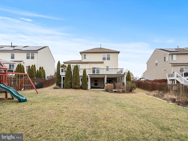 rear view of house featuring a lawn and a playground