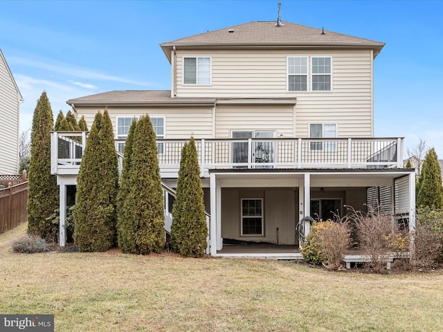 back of property with a wooden deck, a yard, and a patio area