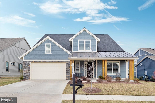 view of front of home with a garage, covered porch, and a front lawn