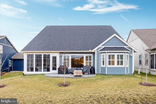 back of house with a patio, a yard, and roof with shingles