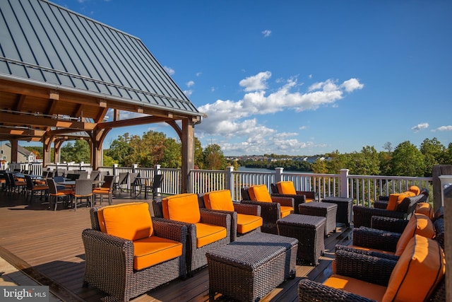 view of patio featuring outdoor dining space, outdoor lounge area, and a deck with water view