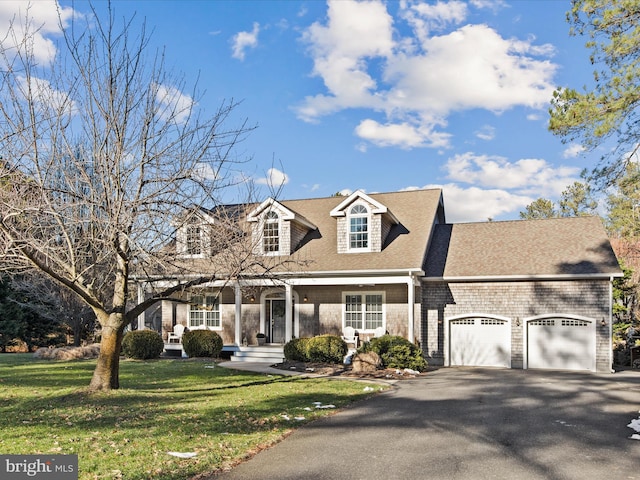 cape cod-style house featuring a garage and a front lawn