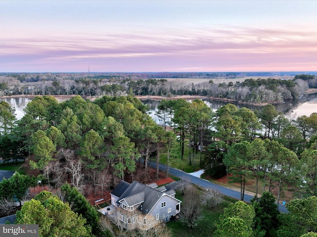 aerial view at dusk featuring a water view