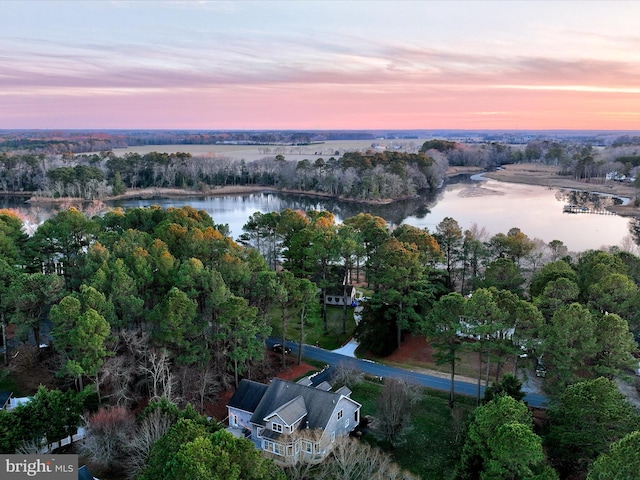 aerial view at dusk featuring a water view