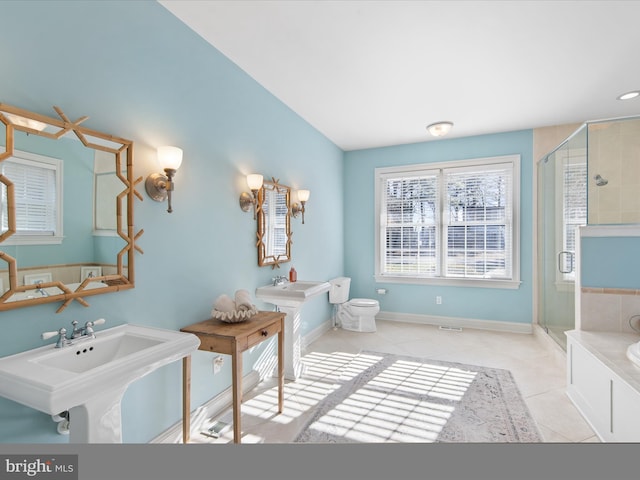 bathroom featuring a shower with door, tile patterned flooring, and dual sinks