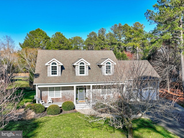 cape cod house featuring a front lawn