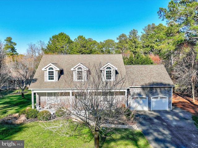 cape cod house with a garage and a front lawn