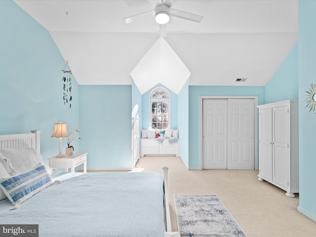 bedroom featuring light carpet, lofted ceiling, a closet, and ceiling fan