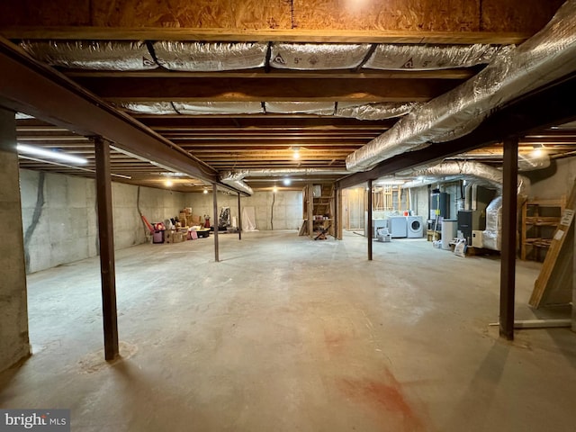 unfinished below grade area with heating unit and washer and dryer