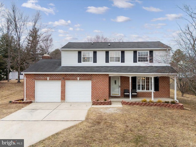 traditional home featuring covered porch, driveway, brick siding, and a garage