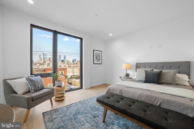 bedroom with access to exterior and light hardwood / wood-style flooring