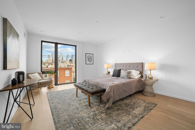 bedroom featuring access to exterior and light hardwood / wood-style floors