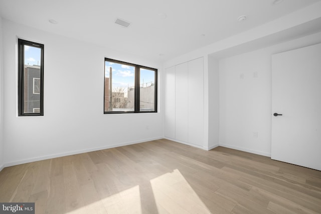 unfurnished room with light wood-type flooring