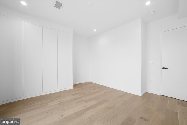 unfurnished bedroom featuring a closet and light wood-type flooring