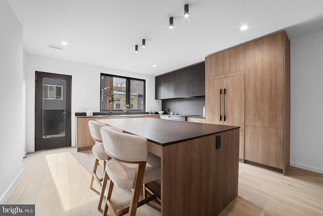 kitchen featuring light hardwood / wood-style flooring, a breakfast bar, and a kitchen island