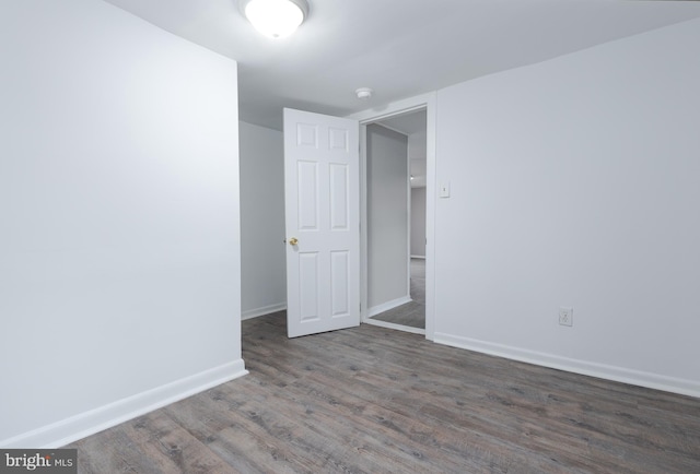 unfurnished room featuring dark wood-type flooring