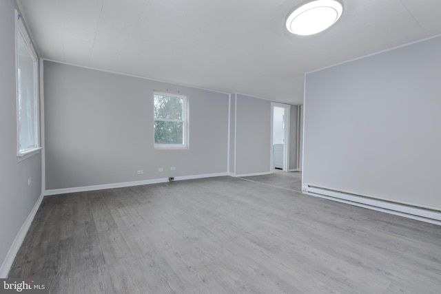 spare room with a baseboard radiator and wood-type flooring