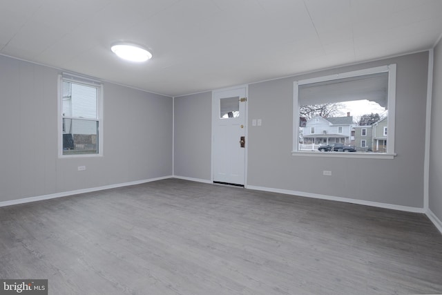 unfurnished room featuring a wealth of natural light and hardwood / wood-style floors