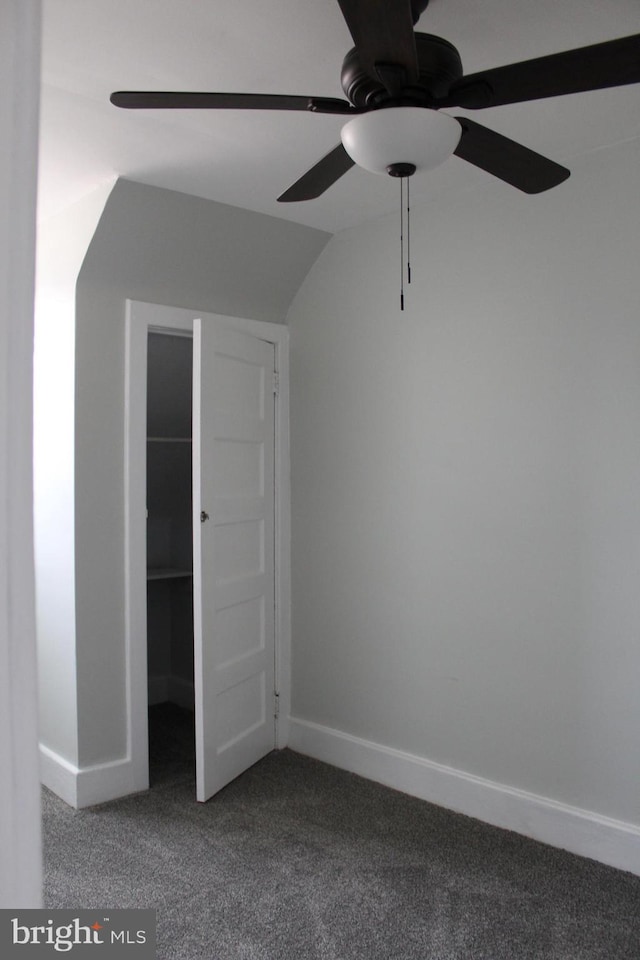 unfurnished bedroom featuring ceiling fan, vaulted ceiling, and carpet