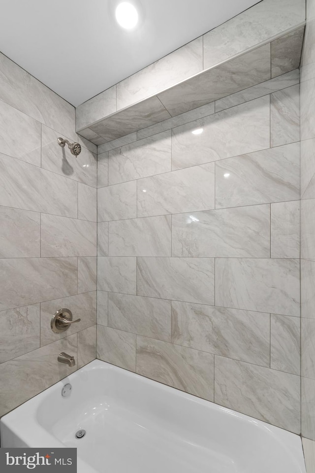 bathroom featuring tiled shower / bath