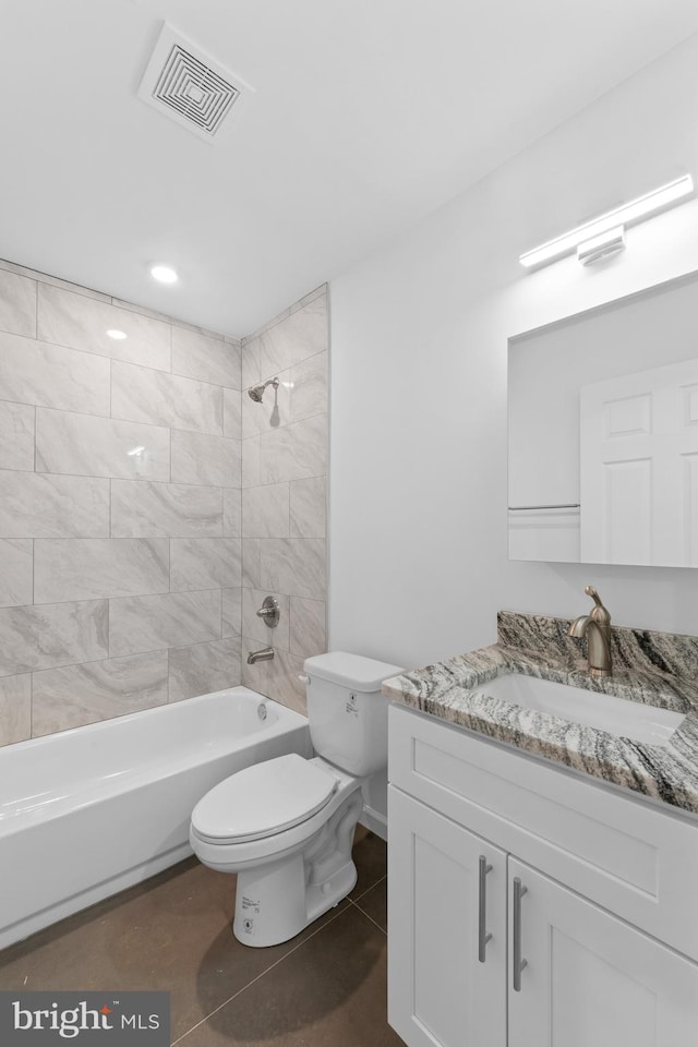 full bathroom with vanity, toilet, tiled shower / bath combo, and tile patterned flooring