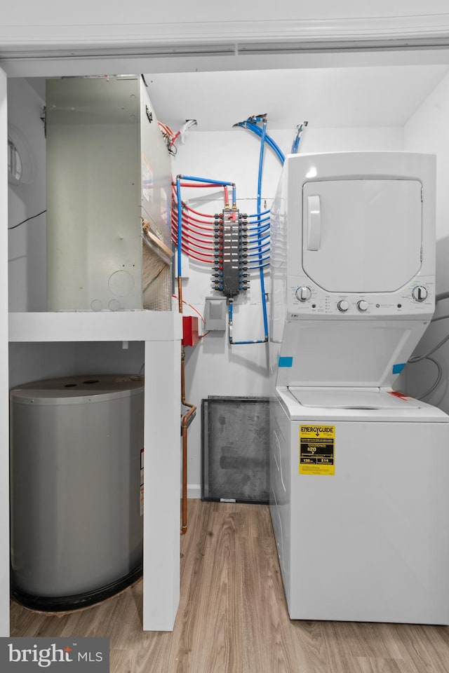 washroom featuring stacked washer / dryer and light wood-type flooring