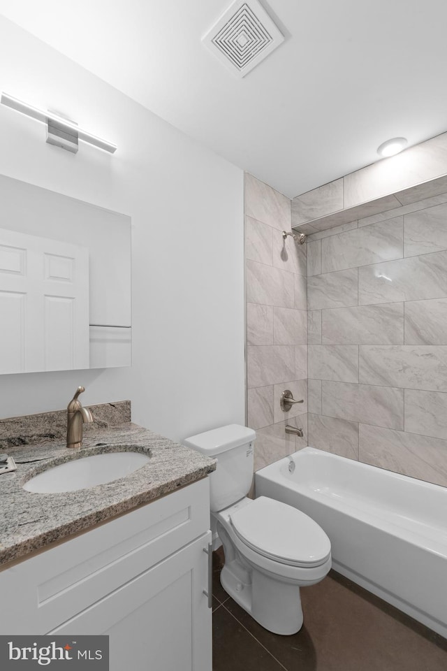 full bathroom featuring vanity, tile patterned floors, toilet, and tiled shower / bath