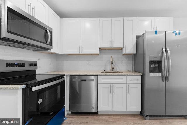 kitchen with stainless steel appliances, sink, and white cabinets