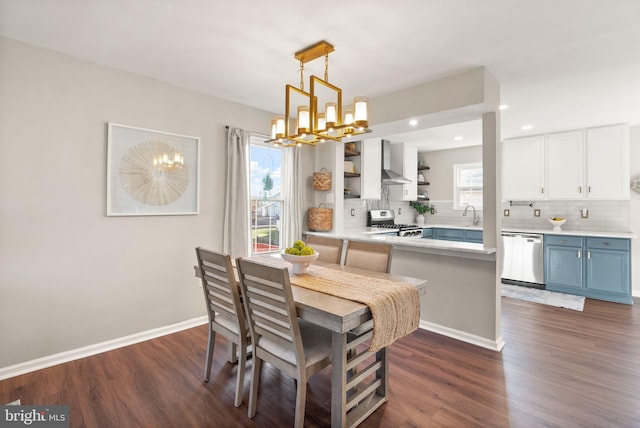 dining room with dark wood-type flooring, sink, and a notable chandelier