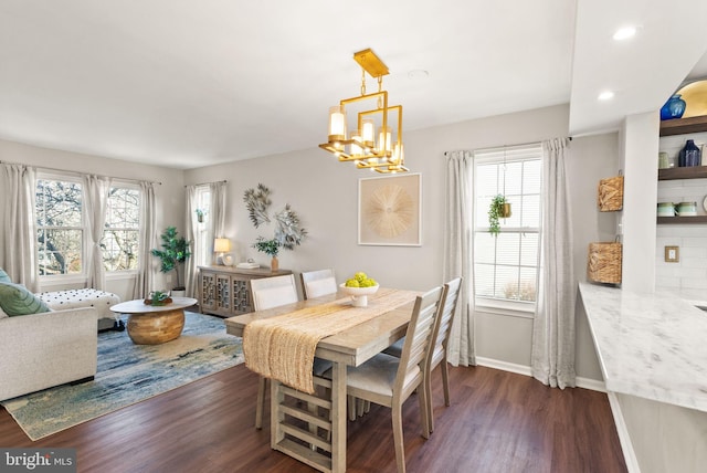 dining area with an inviting chandelier and dark wood-type flooring