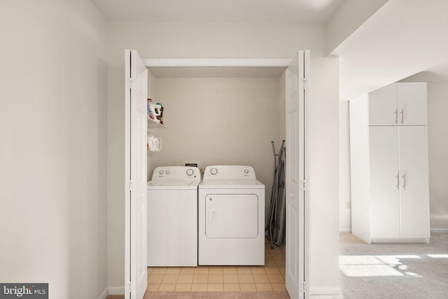 laundry room featuring washing machine and dryer and light tile patterned flooring