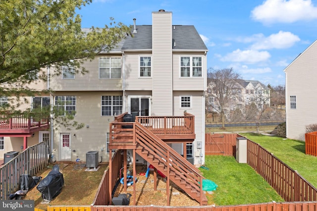 back of property with a wooden deck, a yard, and cooling unit